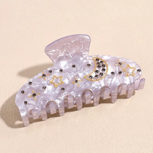 Detail of lavender marble acetate hair claw clip with moon, star motifs and rhinestones