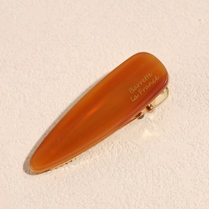 Detail view of amber acetate hair clip with golden Barrette La France text and metal clasp