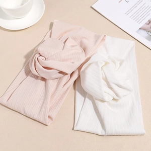Set di due fasce per capelli in maglia a coste rosa e bianca con nodo decorativo