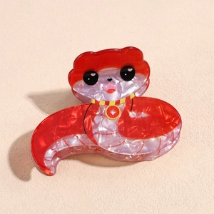 Detail of red and pearl white acrylic snake hair claw clip with golden coin patterns