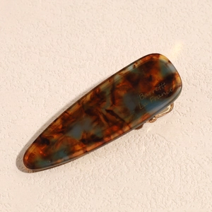 Close-up of tortoise shell resin hair clip with Barrette La France gold engraving
