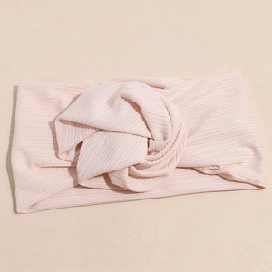 Dettaglio della fascia in maglia a coste rosa con nodo centrale decorativo e tessuto morbido