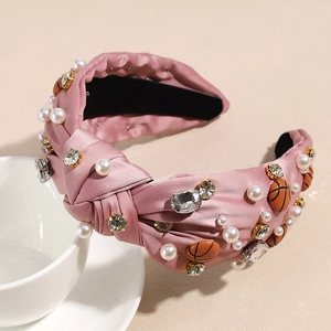 Detailaufnahme von rosa Satin-Stirnband mit Perlen, Straßsteinen und Basketball-Verzierung