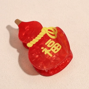 Detail of red acrylic hair claw clip in gourd shape with traditional Fu character design