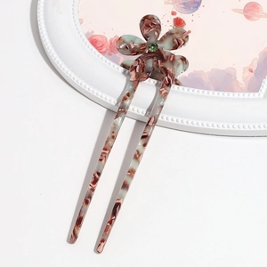 Detail of acetate flower hair pin with green gemstone and marble texture pattern