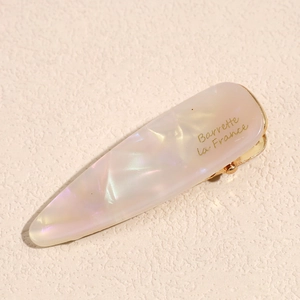 Macro shot of marble texture acetate hair clip with golden Barrette La France text