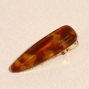 Detailed macro view of tortoise shell acetate hair clip with Barrette La France engraving