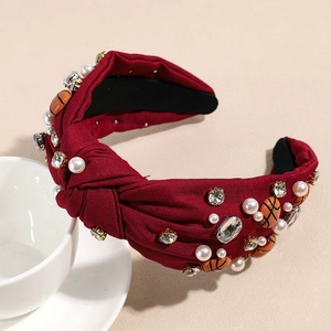 Nahaufnahme bordeauxroter Haarreif mit Knoten, Perlen, Strass und Basketball-Anhänger