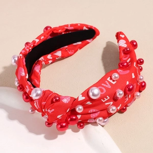 Detail des roten Knotenstirnbands mit LOVE-Herz-Print und dekorativen Kunstperlen