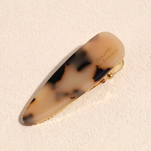 Detail of tortoise shell acetate hair clip with gold metal base and French engraving