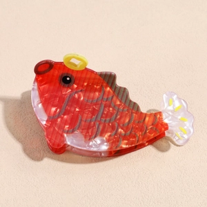 Detail of red koi fish hair claw clip showing pearlescent texture and acetate scales