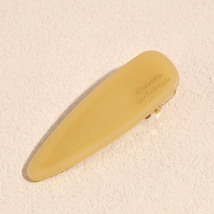 Detail of yellow amber acetate hair clip with golden metal clip and French engraving