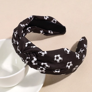 Vue détaillée d'un bandeau à nœud large avec motifs football sur un support en céramique