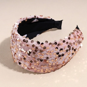 Gros plan sur serre-tête en velours rose avec paillettes dorées et doublure à pois