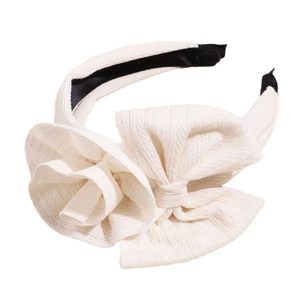 Elegante cerchietto in tessuto crema con fiocco oversize e decorazione floreale