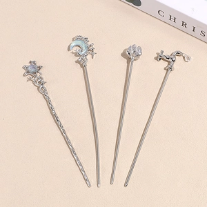 Set of silver artistic hairpins with star, moon and floral charms on beige background