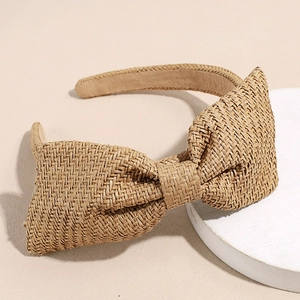 Detailtextuur van raffia haarband met strik in natuurlijk vlechtwerk en stoffen voering