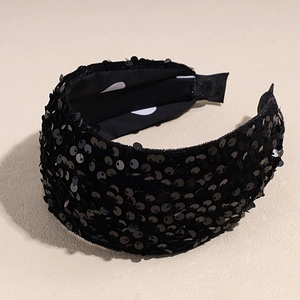 Détail d'un serre-tête large en velours à paillettes noires avec doublure à pois