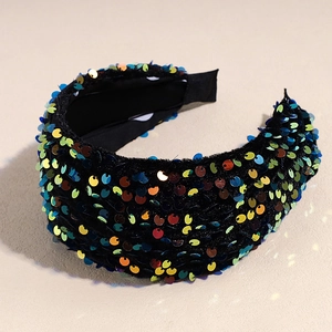 Vue détaillée d'un serre-tête large orné de paillettes multicolores scintillantes sur velours noir