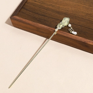 Detail of golden hair stick with green clouds, pearls and traditional tassels