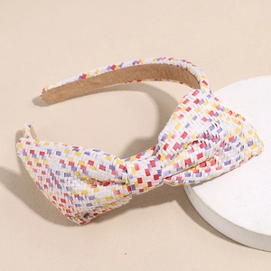 Detail van kleurrijke gevlochten raffia hoofdband met grote strik en zachte voering