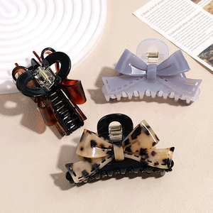 Elegant bow acetate hair claws in leopard print and amber finish for women