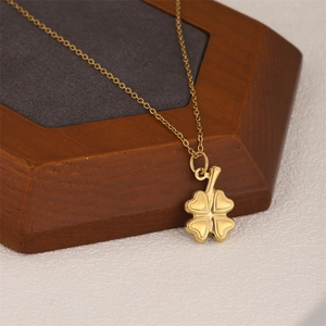 Golden irregular geometric clover pendant necklace displayed on a wooden jewelry stand