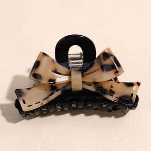 Detailed close-up of acetate bow hair claw clip with France Handmade lettering