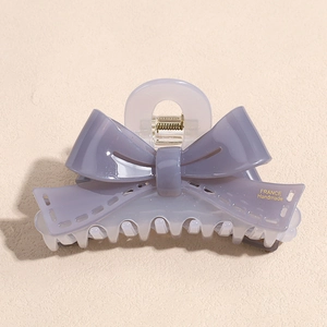 Detail of grey-purple acetate bow hair claw clip featuring a translucent resin finish