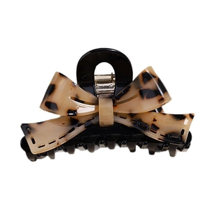Handmade acetate bow hair claw clip with classic tortoiseshell pattern on white background
