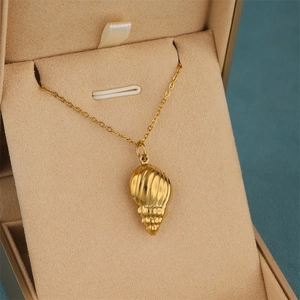 18K gold plated stainless steel ocean conch pendant necklace on beige jewelry box