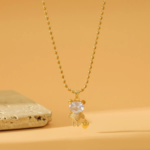 Exquisite goldene Bärenkette mit Zirkonia-Anhänger auf natürlichem Steinhintergrund