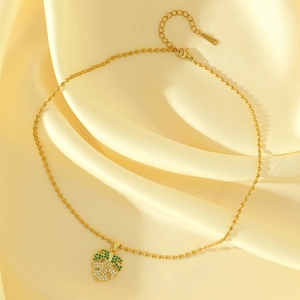Collier feuille de palmier dorée avec oxydes de zirconium sur fond en soie jaune