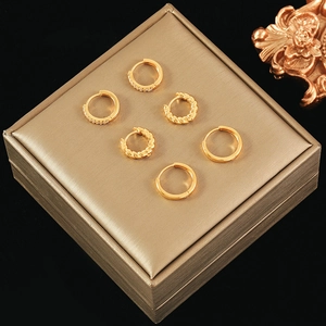 Trois paires de boucles d'oreilles créoles dorées avec zircons et motifs torsadés
