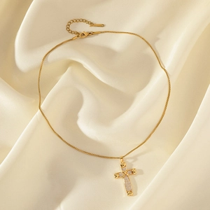 Collier croix plaqué or avec extrémités cœur et zircons sur fond de soie crème