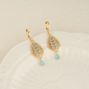 Bohemian 18k gold plated leaf earrings with blue zircon crystals on white vintage plate
