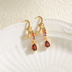 Elegant gold drop earrings featuring pear-cut red zircon and colorful stones on shell tray