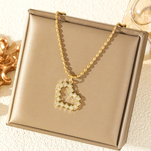 Elegante collana dorata con ciondolo a cuore traforato e zirconi su portagioie