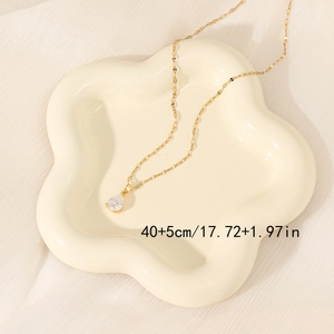 Elegant gold pear-cut cubic zirconia teardrop necklace on a white ceramic tray