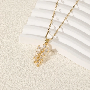 Collier élégant en or avec pendentif fleur en zircon sur un fond blanc à texture ondulée