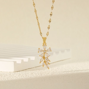 Collier élégant avec pendentif fleur dorée et cristaux de zircon sur fond minimaliste