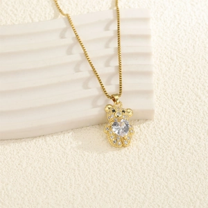 Gros plan d'un pendentif ours doré avec zircon en forme de cœur et cristaux pavés