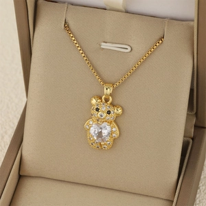 Collier pendentif ourson doré élégant avec zircon en cœur sur une boîte à bijoux