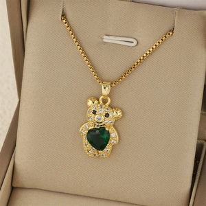 Détail du pendentif ours avec zircon cœur vert et cristaux sur chaîne dorée box