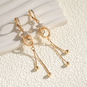 Boucles d'oreilles pendantes dorées avec étoile en strass et détails de cœur élégant