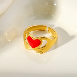 Golden stainless steel open ring featuring a hand-holding red enamel heart design