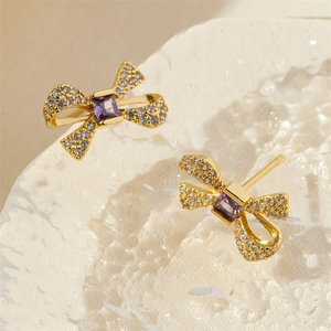 Boucles d'oreilles nœud dorées avec zircon violet et sertissage micro-pavé chic