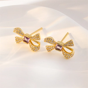 Boucles d'oreilles nœud dorées avec zircone violette et cristaux micro-pave