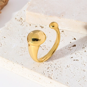 Anello aperto in acciaio inossidabile placcato oro 18k con doppia sfera su sfondo di pietra