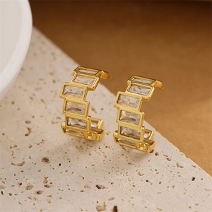 Boucles d'oreilles créoles C dorées avec zircons taille baguette sur pierre blanche